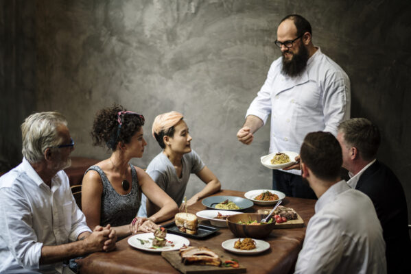 chef in a famous restaurant giving menu talk to the guests 